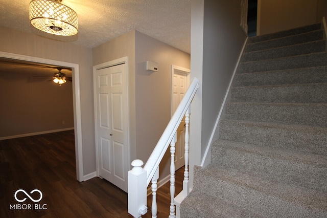 stairway featuring ceiling fan, hardwood / wood-style floors, and a textured ceiling