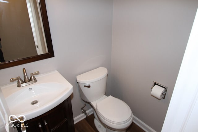 bathroom with hardwood / wood-style floors, vanity, and toilet