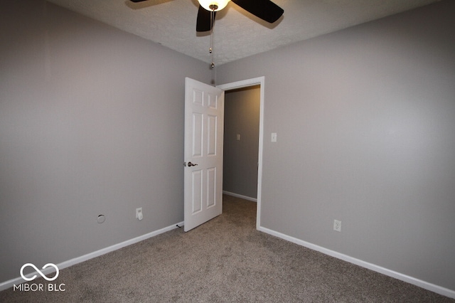 empty room featuring ceiling fan, carpet, and a textured ceiling