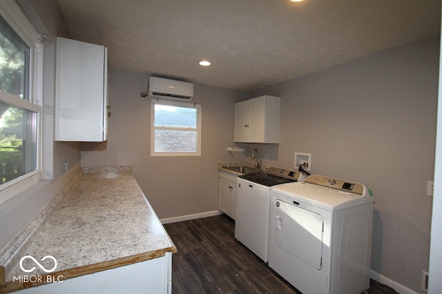 laundry area with sink, a wall mounted AC, washer and dryer, cabinets, and dark hardwood / wood-style flooring