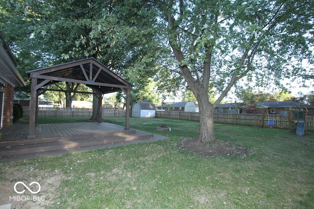 view of yard featuring a gazebo, a deck, and a storage shed