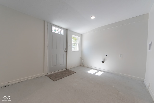 carpeted foyer entrance featuring vaulted ceiling