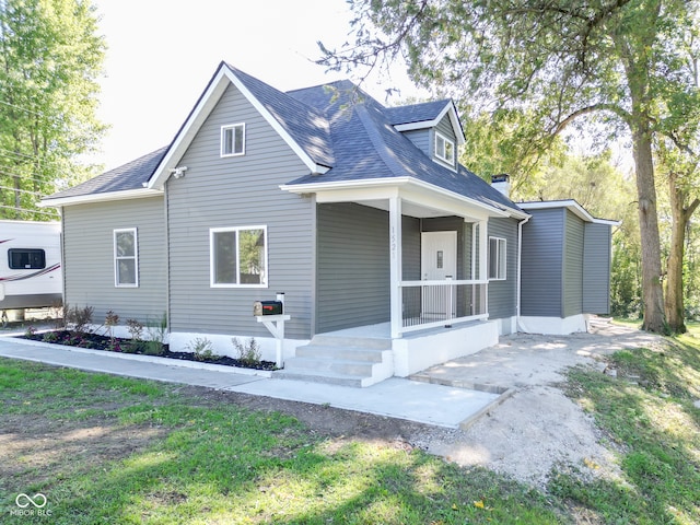 view of side of property with a lawn and covered porch