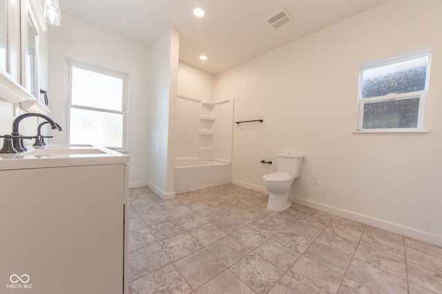 bathroom featuring vanity, washer / clothes dryer, a healthy amount of sunlight, and toilet