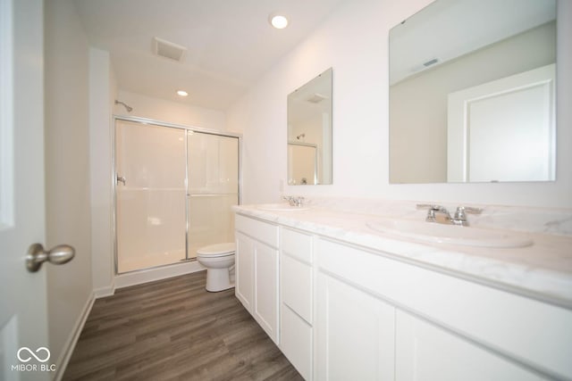 bathroom featuring visible vents, a stall shower, toilet, and a sink