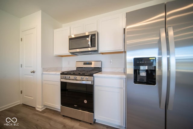 kitchen featuring white cabinetry, stainless steel appliances, light countertops, and dark wood-type flooring