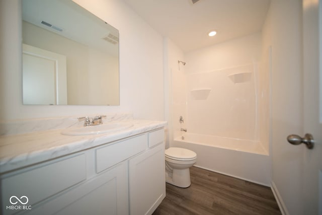 full bathroom with vanity, toilet,  shower combination, and hardwood / wood-style floors