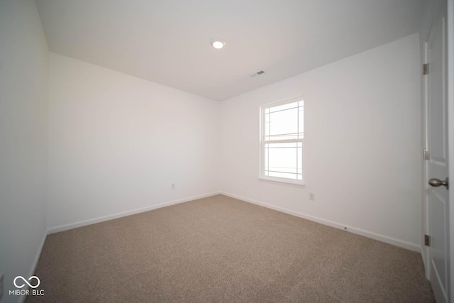 carpeted empty room with visible vents and baseboards