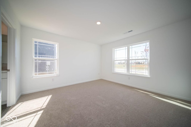 spare room with carpet, visible vents, recessed lighting, and baseboards