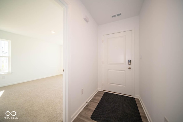 doorway to outside featuring baseboards and visible vents