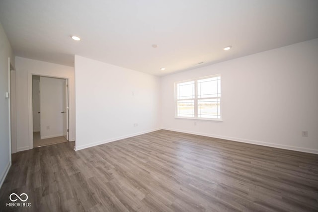 spare room with wood finished floors, recessed lighting, and baseboards