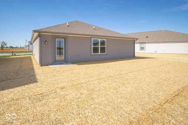 back of property with a shingled roof