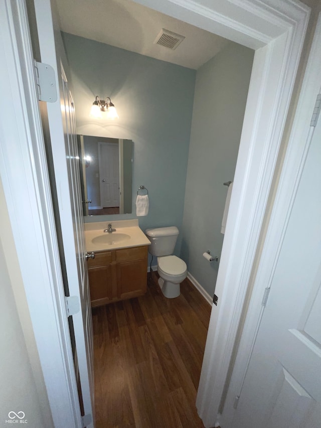 bathroom featuring hardwood / wood-style flooring, vanity, and toilet