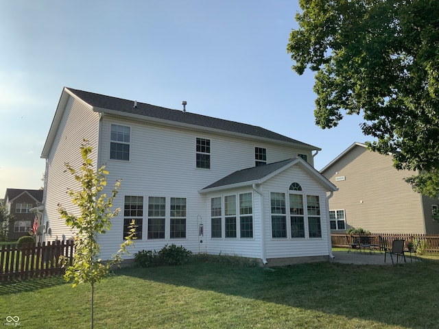 rear view of house featuring a lawn