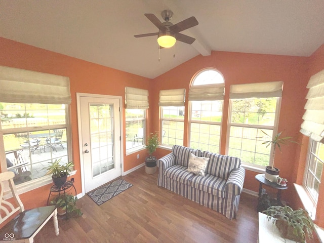 living room featuring ceiling fan, wood-type flooring, lofted ceiling with beams, and plenty of natural light