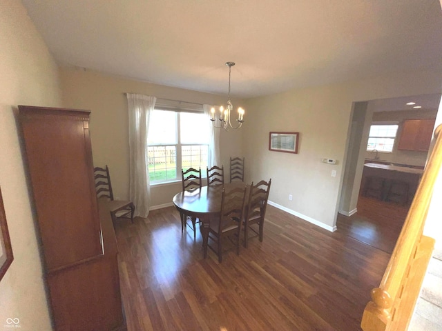 dining area with dark wood-type flooring and a chandelier