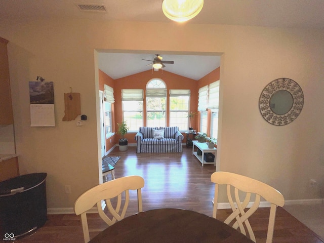 dining space with ceiling fan, dark hardwood / wood-style floors, and vaulted ceiling