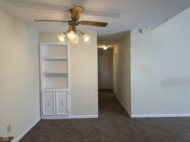 unfurnished room featuring ceiling fan, dark carpet, and a textured ceiling