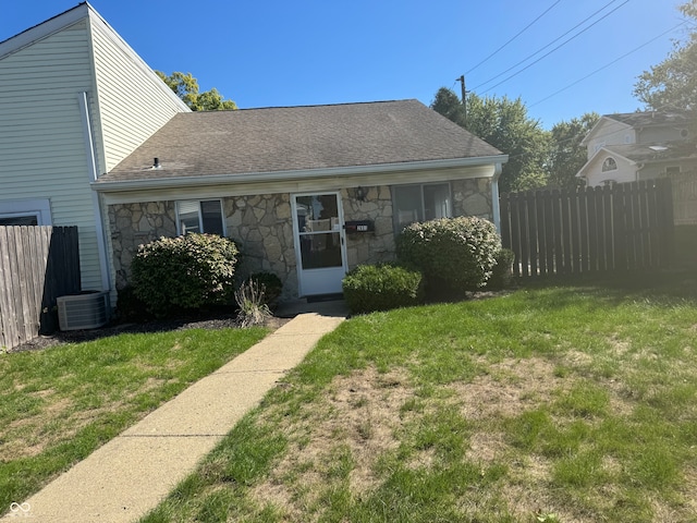 view of front of property with central AC unit and a front lawn