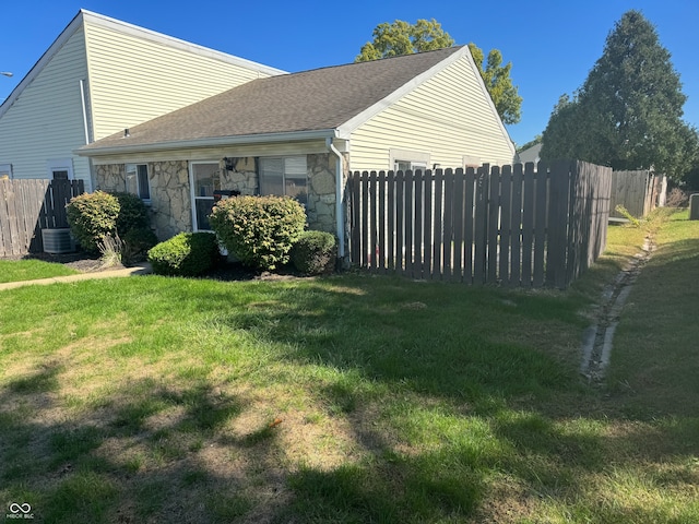 view of side of home with a lawn and cooling unit