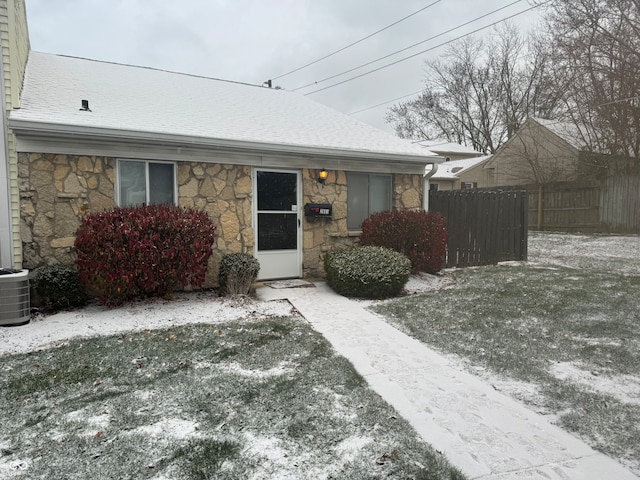 ranch-style house with cooling unit and a front lawn