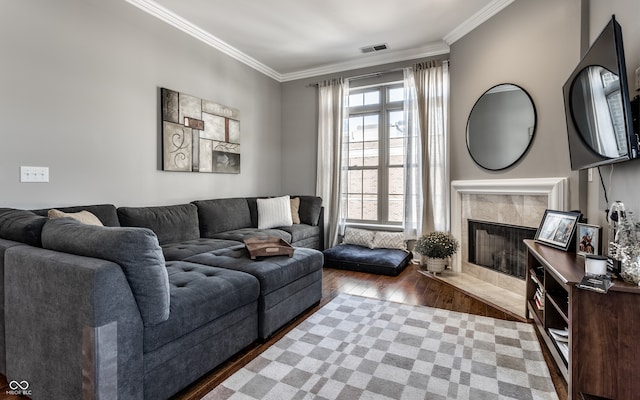 living room featuring dark hardwood / wood-style floors, crown molding, and a tile fireplace