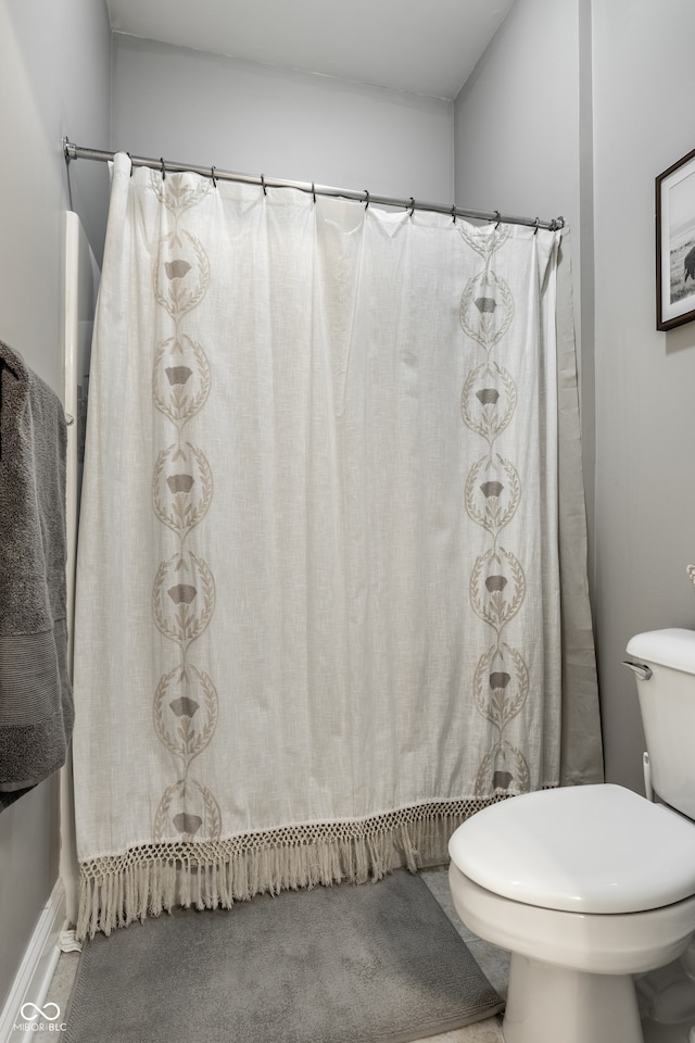 bathroom featuring walk in shower and toilet