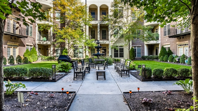 view of home's community featuring a patio and a lawn