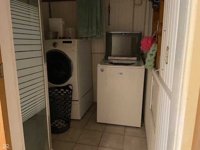 clothes washing area with independent washer and dryer and light tile patterned floors