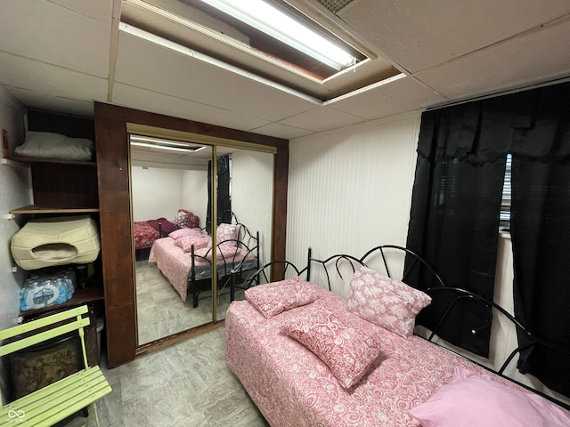 bedroom with a closet and a paneled ceiling