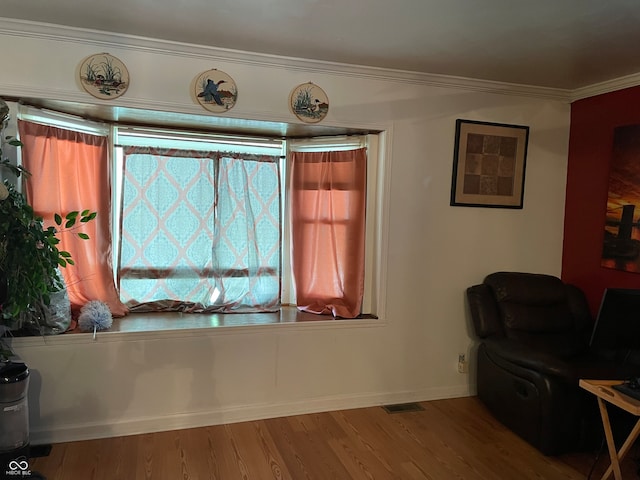 living area featuring ornamental molding and wood-type flooring