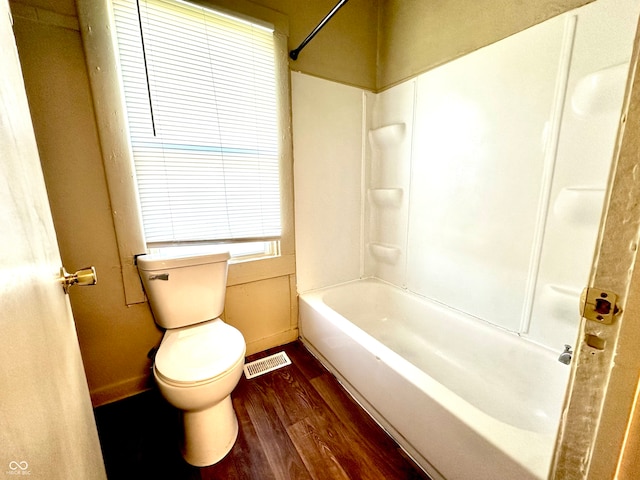 bathroom featuring shower / bathtub combination, toilet, and hardwood / wood-style flooring