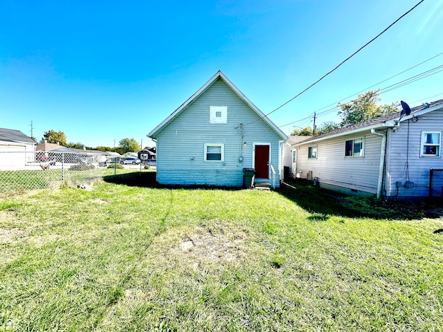 rear view of house featuring a yard