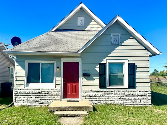 bungalow-style home with a front yard