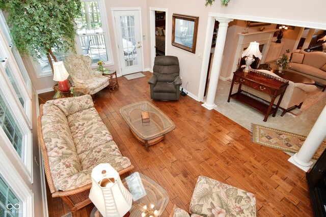 living room with baseboards, hardwood / wood-style flooring, and decorative columns