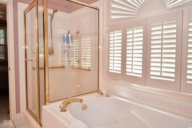 full bathroom with a tub with jets, tile patterned floors, and a stall shower
