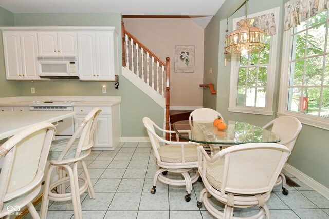 dining room with an inviting chandelier, light tile patterned flooring, stairs, and baseboards