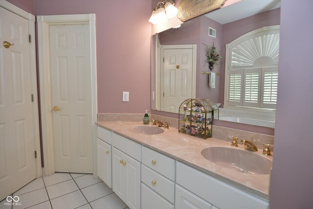 bathroom with a garden tub, tile patterned flooring, a sink, and visible vents
