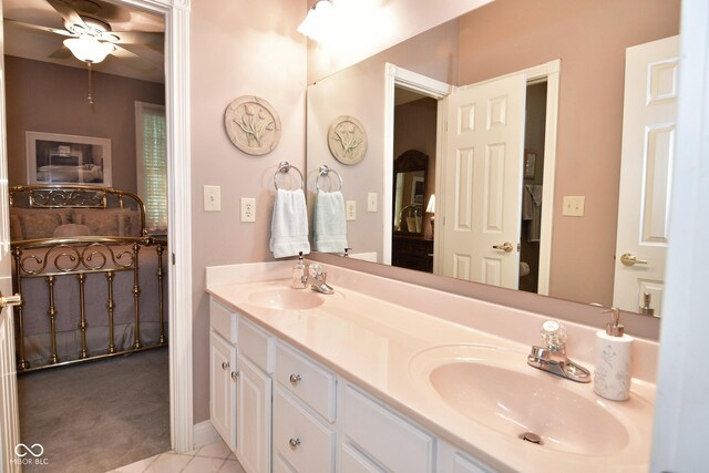 ensuite bathroom with double vanity, connected bathroom, a ceiling fan, and a sink