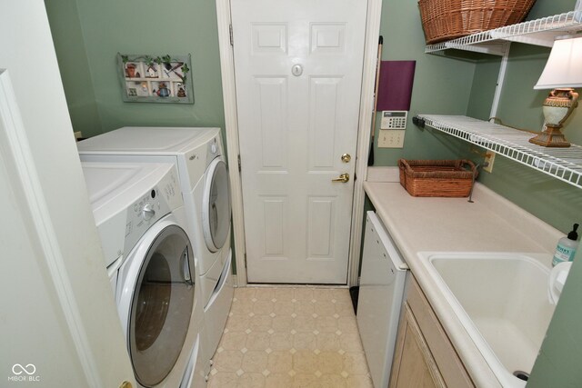 washroom featuring a sink, independent washer and dryer, light tile patterned floors, and cabinet space