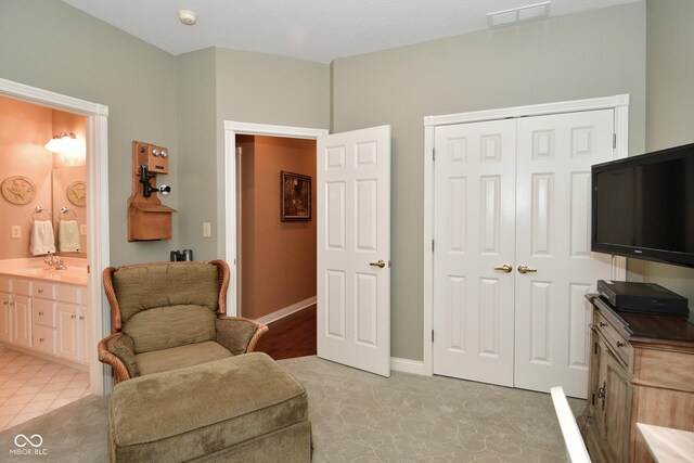 sitting room featuring light colored carpet, baseboards, and visible vents