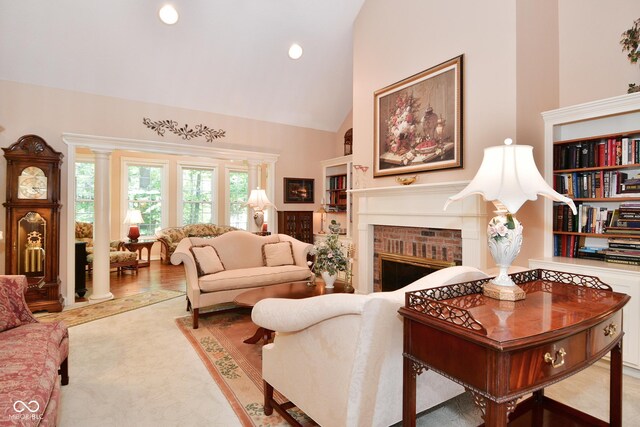 living area with high vaulted ceiling, a brick fireplace, and recessed lighting