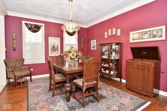 dining space with hardwood / wood-style floors, baseboards, a wealth of natural light, and a notable chandelier