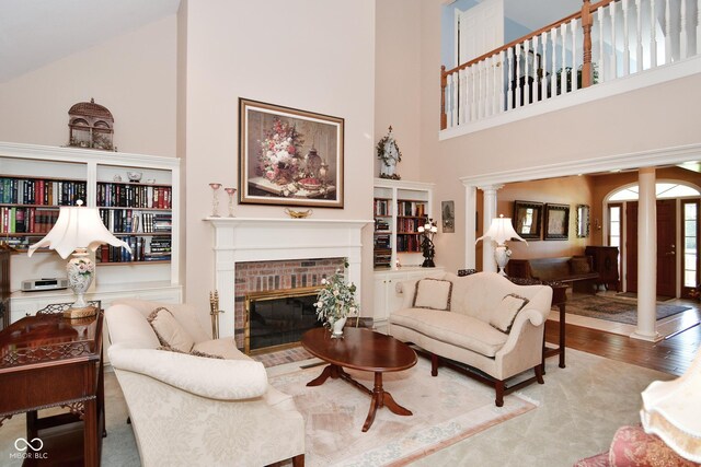 living room with a fireplace, wood finished floors, and high vaulted ceiling