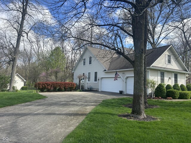 view of side of property featuring an attached garage, a shingled roof, a yard, and concrete driveway