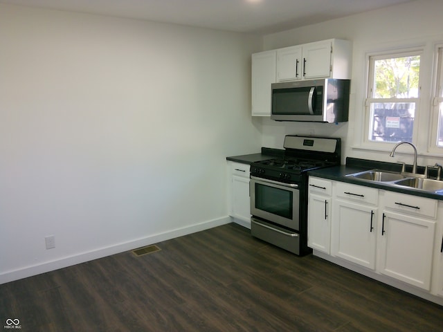 kitchen featuring white cabinets, appliances with stainless steel finishes, dark hardwood / wood-style floors, and sink