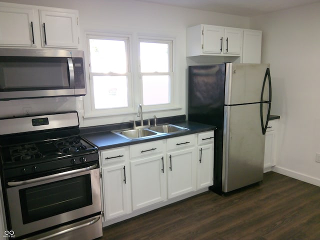 kitchen with stainless steel appliances, white cabinets, dark wood-type flooring, and sink