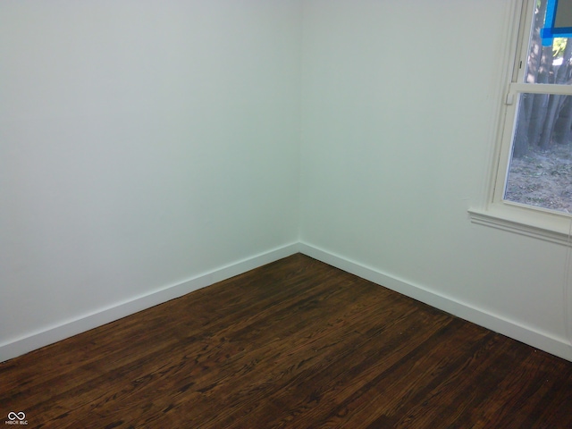 spare room with dark wood-type flooring