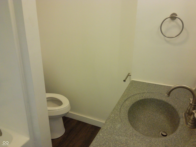 bathroom featuring toilet, hardwood / wood-style floors, and sink