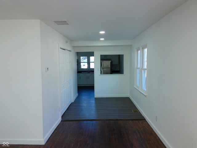 corridor with dark hardwood / wood-style flooring